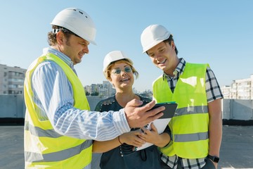 Team of builders engineer architect on the roof of construction site. Building, development,...