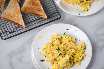 Räucherlachs Rührei mit Dill und Vollkorn Toast auf Marmor Hintergrund