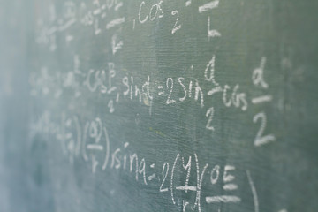 Math formula on blackboard background in classroom. Education and activity in classroom concept.