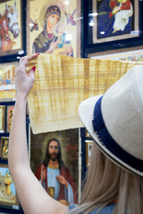 Obraz na płótnie Canvas Young girl holding papyrus in a souvenir shop in Egypt