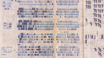 Transportation aerial view from drone top view new cars lined up in the port for import and...