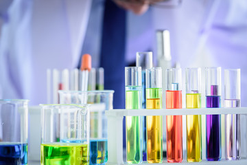 Asian Laboratory scientist man working at lab with test tubes.