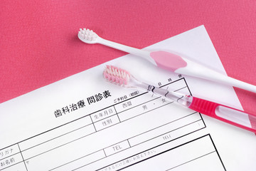 歯の治療の問診票と歯ブラシ、歯医者の予約