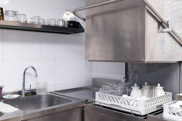 Clean utensils in the dishwasher. Wine glasses, beer mugs, ceramic teapots. Concept of preparation for opening, banquet, catering, buffet table