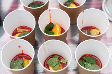Fruit tea with cinnamon rolls, lemon and mint in paper cups