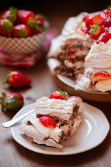 Piece of chocolate meringue cake Pavlova with whipped cream and fresh strawberry