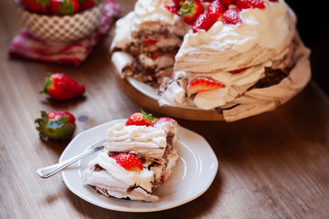 Piece of chocolate meringue cake Pavlova with whipped cream and fresh strawberry