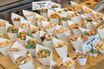 Roasted mixed nuts in white paper bowl on barble table in San Miguel Market Madrid