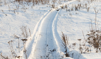 Obraz premium Snowmobile trail in the snow in the field