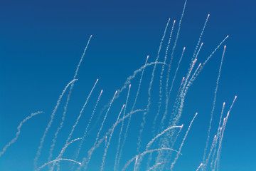 Flares with a trail of smoke on blue sky background