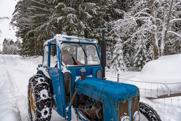 Fototapeta na wymiar old blue fordson dexta tractor plowing snow