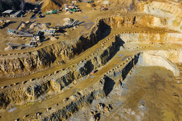 Aerial view of opencast mining quarry with lots of machinery. Industrial place view from above. Photo captured with drone.