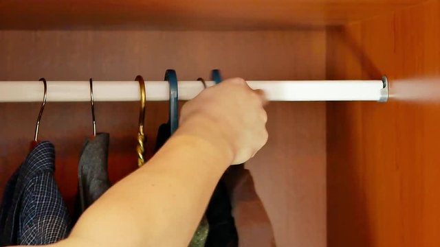 mans hand taking off casual wear from wardrobe hanger and put back formal shirts and office suit. close-up 4k video footage