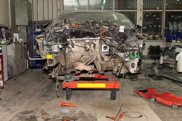 A broken car with a violation of geometry is on the stocks for leveling and repair in the workshop and auto service for the restoration of vehicles with building berth without engine