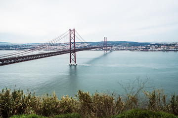 Fototapeta na wymiar Panoramic view of Ponte 25 de Abril, long bridge in Lisbon, Portugal