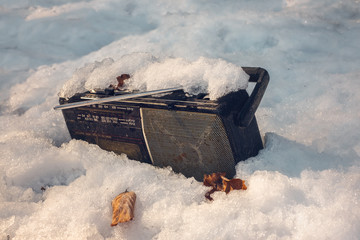 Old radio cassette player abandoned in the snow