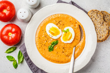 Homemade Spanish salmorejo with egg in white plate, top view.