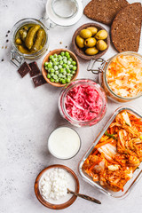 Probiotics food concept. Kimchi, beet sauerkraut, sauerkraut, cottage cheese, peas, olives, bread, chocolate, kefir and pickled cucumbers.