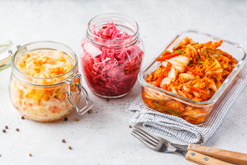 Korean kimchi cabbage, beet sauerkraut and sauerkraut in glass jars, white background.