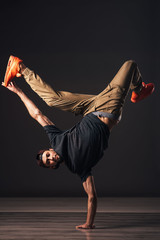 A man hip hop dancer or bboy freezes in one pose on the hand