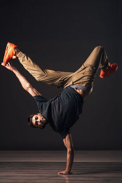A man hip hop dancer or bboy freezes in one pose on the hand