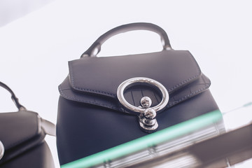 Luxury women's bag made of genuine leather on the shelf in the accessories store