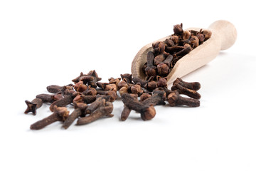 Cloves in wooden scoop isolated on white background. Closeup.