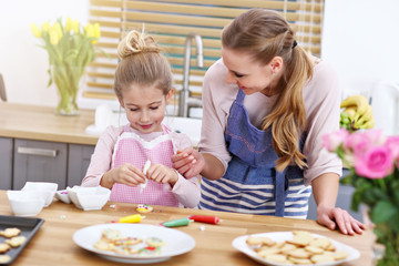 Mother and daughter preparing cookies in the kitchen