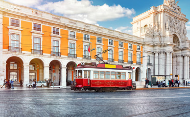 Lisbon, Portugal. Red touristic tram at Praca do Comercio (Commercial Square) near Triumphal Arch of Rua Augusta. Sunny day in famous tourist place of Lisboa.
