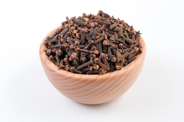 Cloves in wooden bowl isolated on white background.