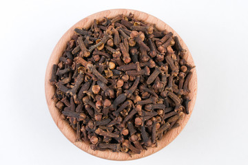 Cloves in wooden bowl isolated on white background.