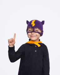 Little superhero smiling and pointing up