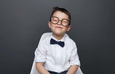 Charming grimacing boy in shirt and glasses