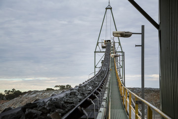 Ore on a conveyor belt heading up to a rock crusher at a mine in NSW, Australia