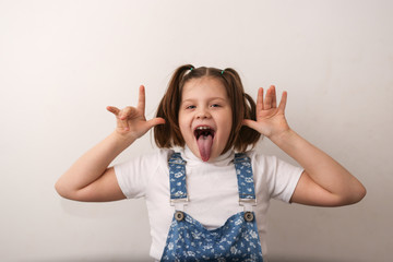 funny girl child with grimaces, shows tongue © natalialeb