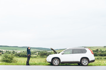 angry man at roadside with broken car