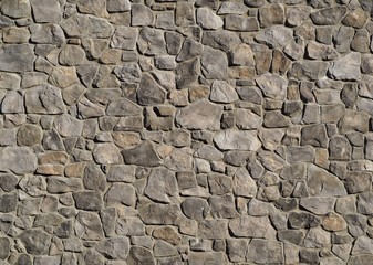 Massive exterior wall cladding made of gray natural stones with different sizes and shapes