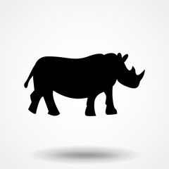Vector illustration of a silhouette of a rhino standing on isolated white background. Rhinoceros side view profile.