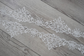 wooden background with spring flowers roses and lace ribbon. Happy womans day. The texture of lace on wooden background.