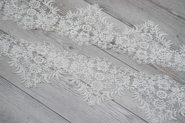 wooden background with spring flowers roses and lace ribbon. Happy womans day. The texture of lace on wooden background.