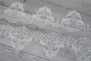 Obraz premium wooden background with spring flowers roses and lace ribbon. Happy womans day. The texture of lace on wooden background.
