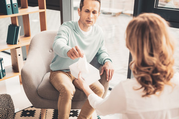 Man taking napkin while suffering from allergy