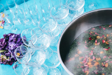 Salad bowl filled with strawberry and mint cocktail with cocktail glasses in a blue environment