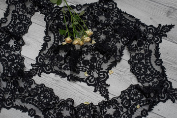 wooden background with spring flowers roses and lace ribbon. Happy womans day. The texture of lace on wooden background.