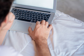 Young man using laptop with white screen