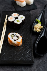 Sushi Set sashimi and sushi rolls served on stone slate 