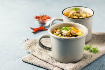 Fish soup in mugs with fresh herbs and lemon. Selective focus, space for text.