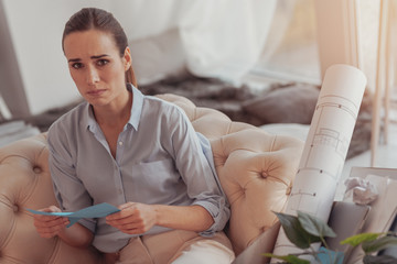 Downhearted woman with unpleasant letter from her boss