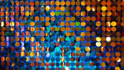 Close up gold sequins reflective background with blue color light.