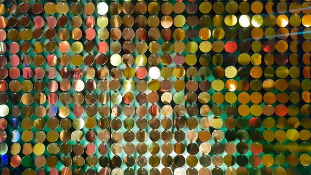 Close up gold sequins reflective background with red, green color light.